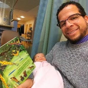 Bobby reading to one of his daughters in the NICU