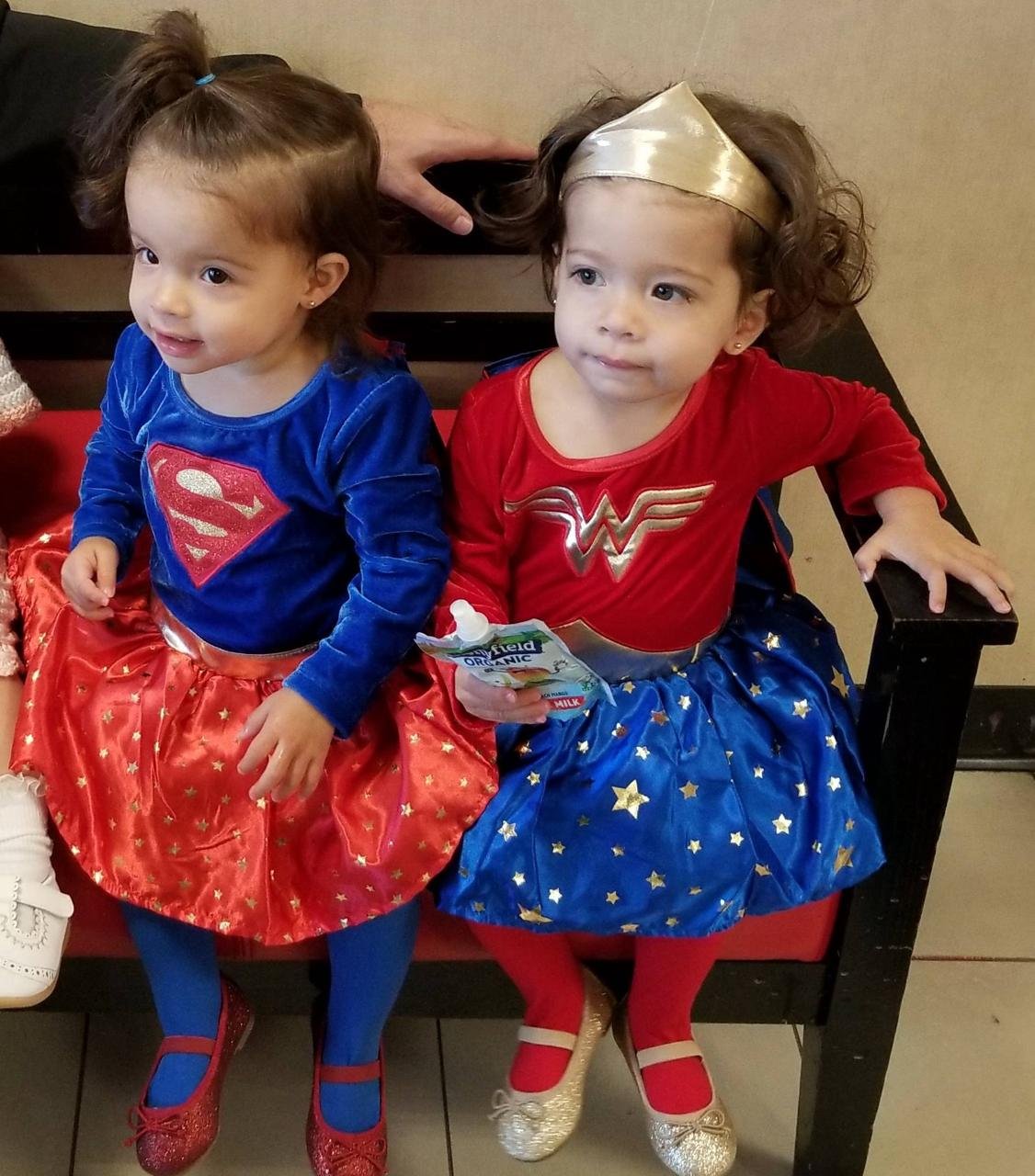 Charlie and JoJo as toddlers dressed as Supergirl and Wonder Woman